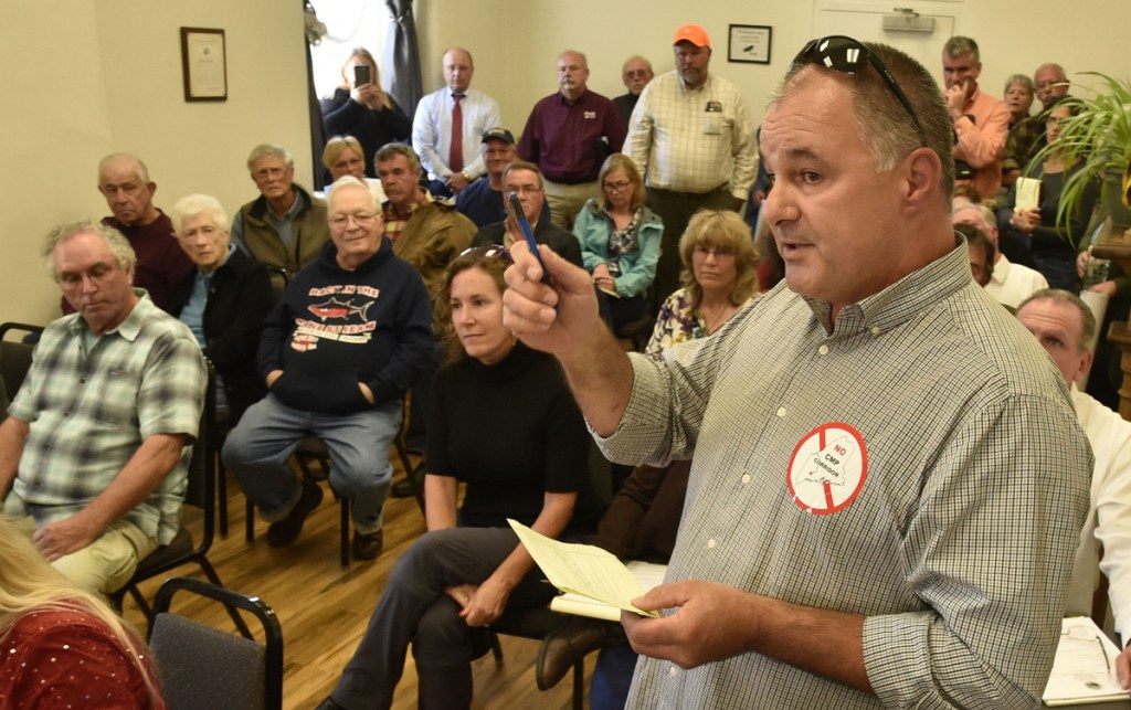 Wearing a sticker protesting the CMP New England Clean Energy Corridor project, Tom Michaud and others express opposition to the project during a Somerset County commissioners meeting in Skowhegan on Wednesday.