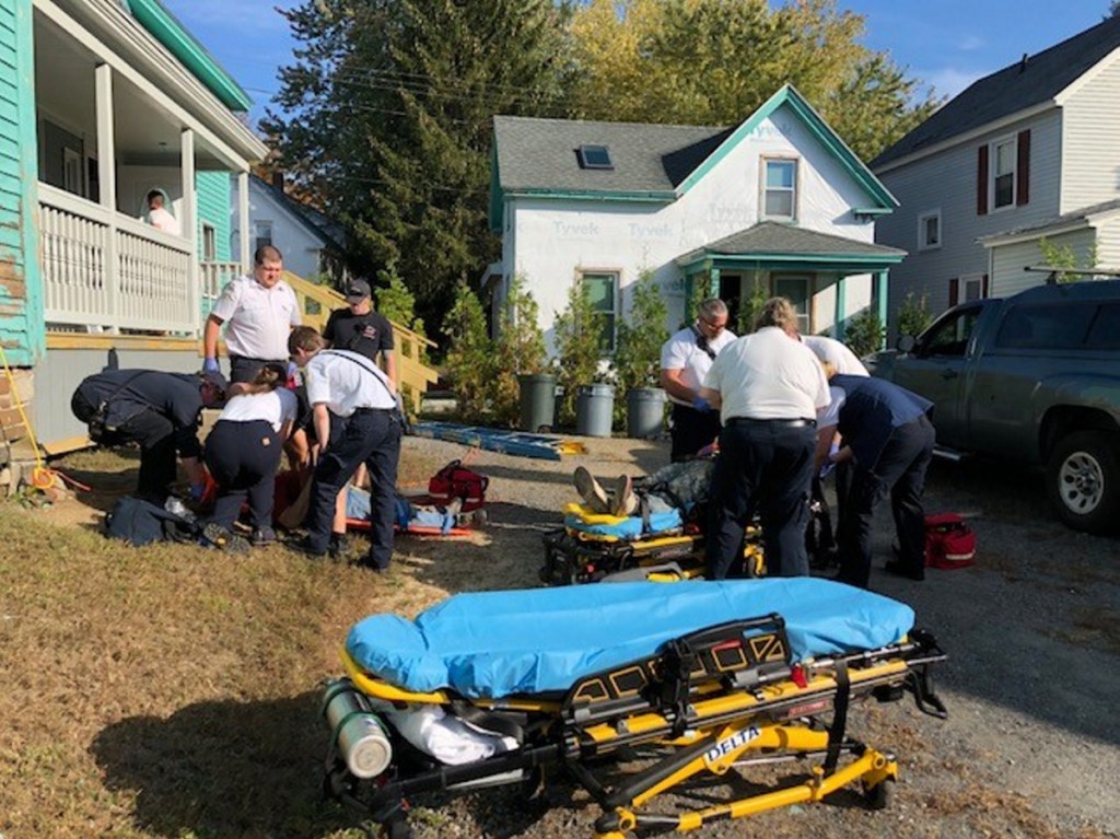 Emergency responders attend to two men who reportedly fell off roof scaffolding Wednesday morning in Waterville.