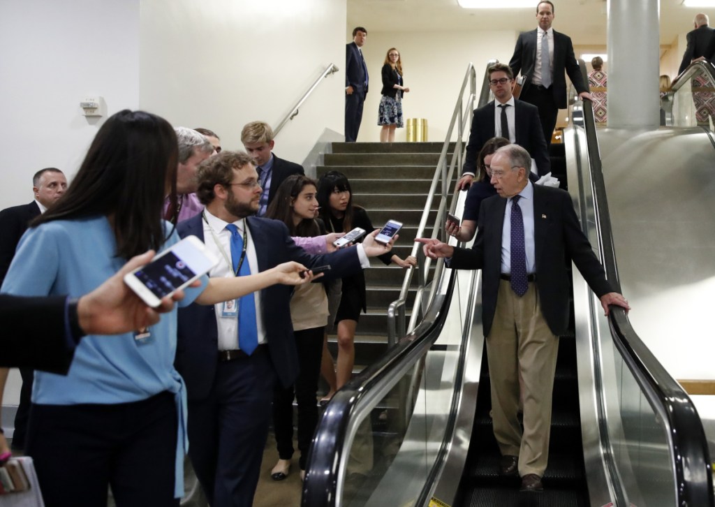 Senate Judiciary Committee Chairman Chuck Grassley, R-Iowa, talks with reporters as he uses the escalator on Capitol Hill on Wednesday in Washington.