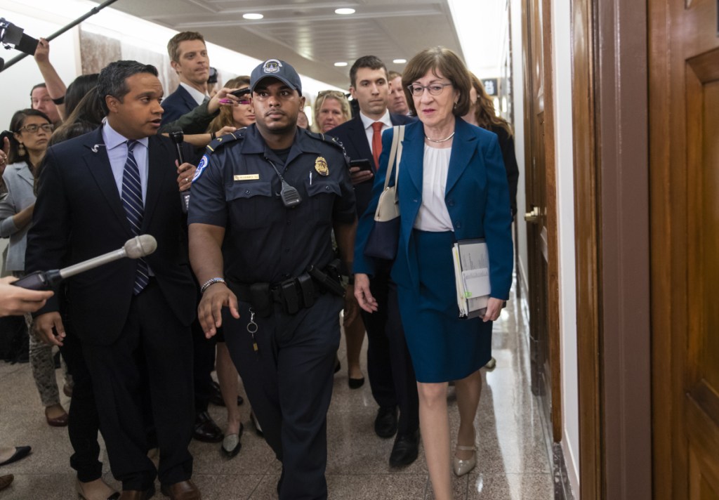 Sen. Susan Collins, R-Maine, is escorted by U.S. Capitol Police as she is met by cameras and reporters asking about embattled Supreme Court nominee Brett Kavanaugh, on Capitol Hill in Washington on Wednesday. Collins was arriving to chair the Senate Special Committee on Aging. Associated Press/ J. Scott Applewhite