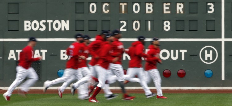 Red Sox players jog in the outfield during a workout at Fenway Park on Wednesday. The Red Sox will host Game 1 of the American League Division Series on Friday night against the Yankees or Athletics.
