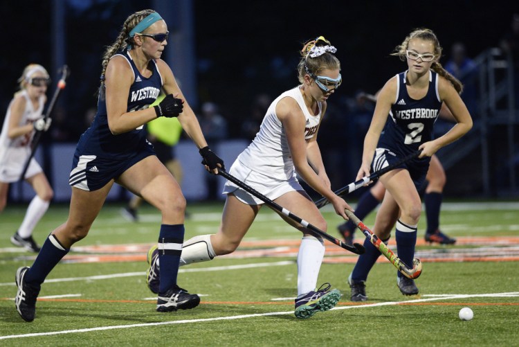 Biddeford's Abby Allen splits Westbrook defenders Avery Tucker, left and Abigail Symbol, in Friday's field hockey showdown at Biddeford. Allen scored one of the goals in the Tigers' 2-0 win.