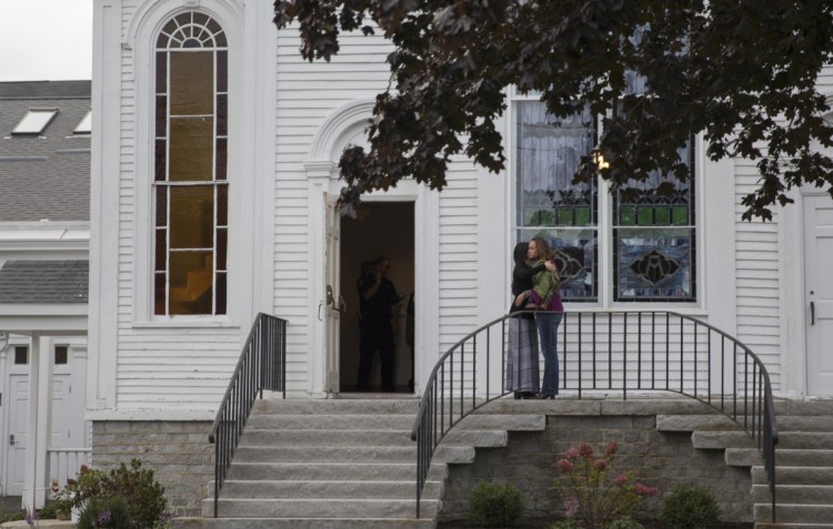 Two women hug outside of the Congregational Church in Cumberland before attending a prayer vigil for Kristin Westra on Saturday.