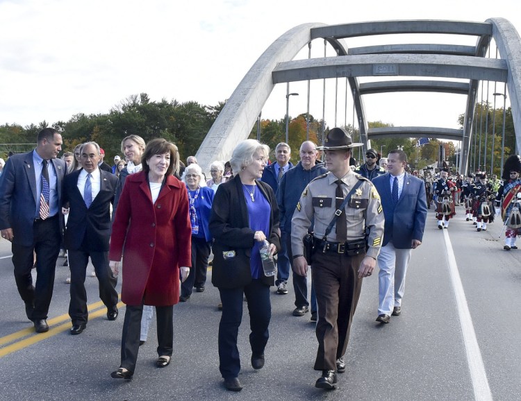 Sheryl Cole, center, walks with Sen. Susan Collins and her son, Somerset County Sheriff's Deputy David Cole, as they and hundreds of others cross the newly dedicated Cpl. Eugene Cole Memorial Bridge, named in honor of her husband, in Norridgewock on Sunday. Walking at left of Collins is U.S. Rep. Bruce Poliquin.