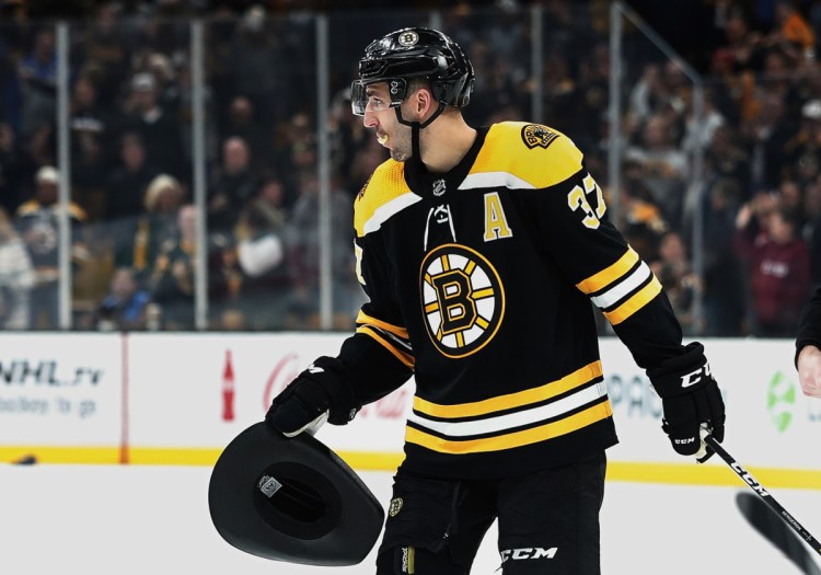 Boston's Patrice Bergeron carries a cowboy hat to the bench after scoring his third goal of the game in the Bruins' 6-3 win over the Ottawa Senators on Monday in Boston.