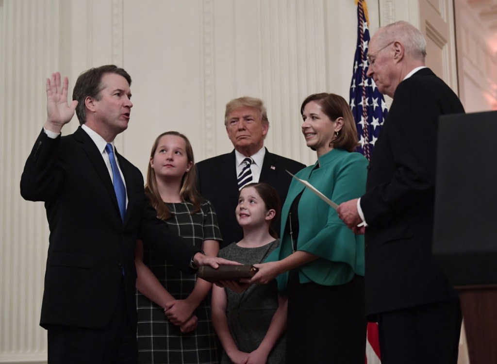 Retired Justice Anthony Kennedy, right, swears in Brett Kavanaugh at the White House as President Trump and Kavanaugh's family watch Monday.