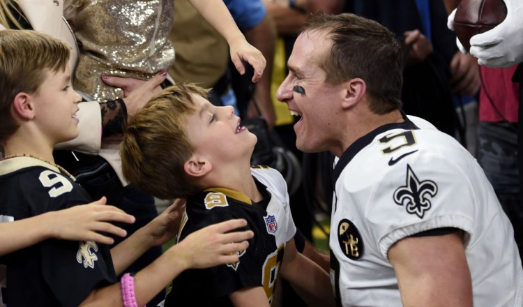 Saints quarterback Drew Brees greets his family after he broke the NFL all-time passing yards record in the first half of the Saints' 43-19 win over Washington on Monday in New Orleans.