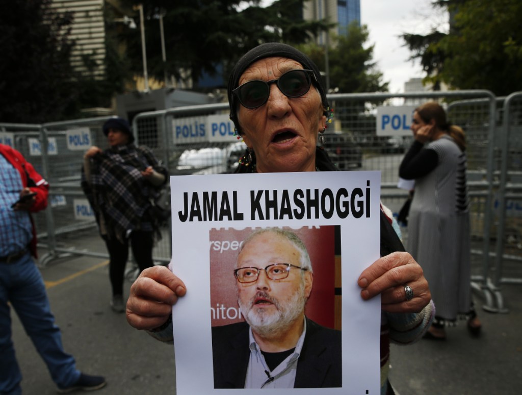 At left, a member of the Human Rights Association Istanbul branch, holds a poster with a photo of missing Saudi journalist Jamal Khashoggi, during a protest on Tuesday.