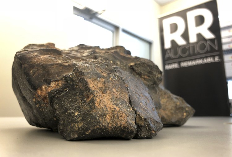 A lunar meteorite found in Northwest Africa last year rests on a table in Amherst, N.H. The rock could sell for $500,000 or more in an online auction that runs from Thursday until Oct. 18.