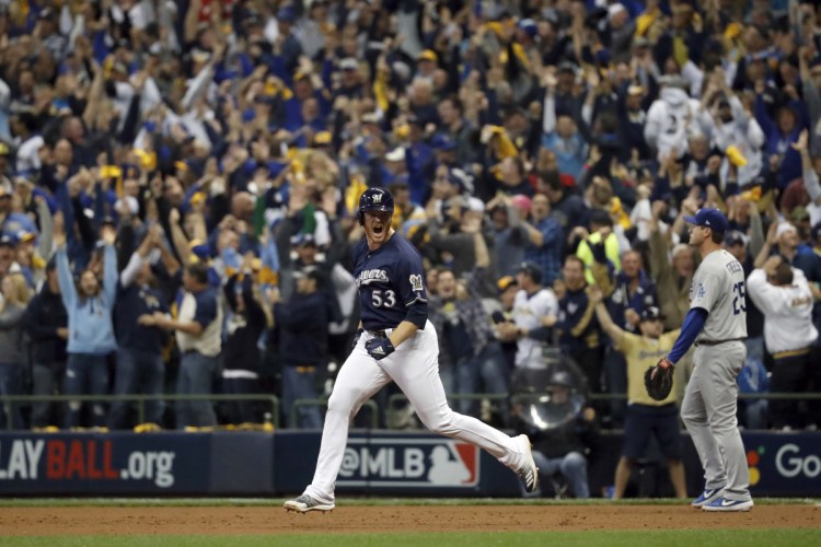 Milwaukee reliever Brandon Woodruff celebrates after hitting a home run during the third inning against Los Angeles on Friday in Milwaukee. The Brewers beat the Dodgers, 6-5 to take Game 1 of the series.