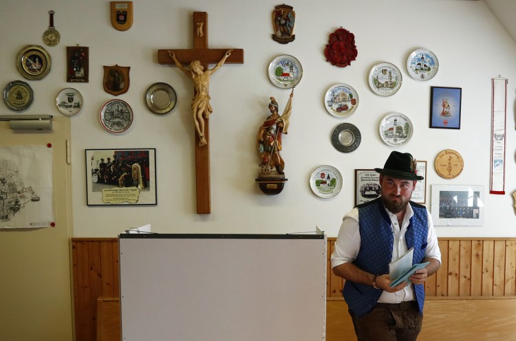 A man in traditional Bavarian clothes casts his vote. Sunday's results scrambled politics in a region that has been one of the most politically stable in Europe.