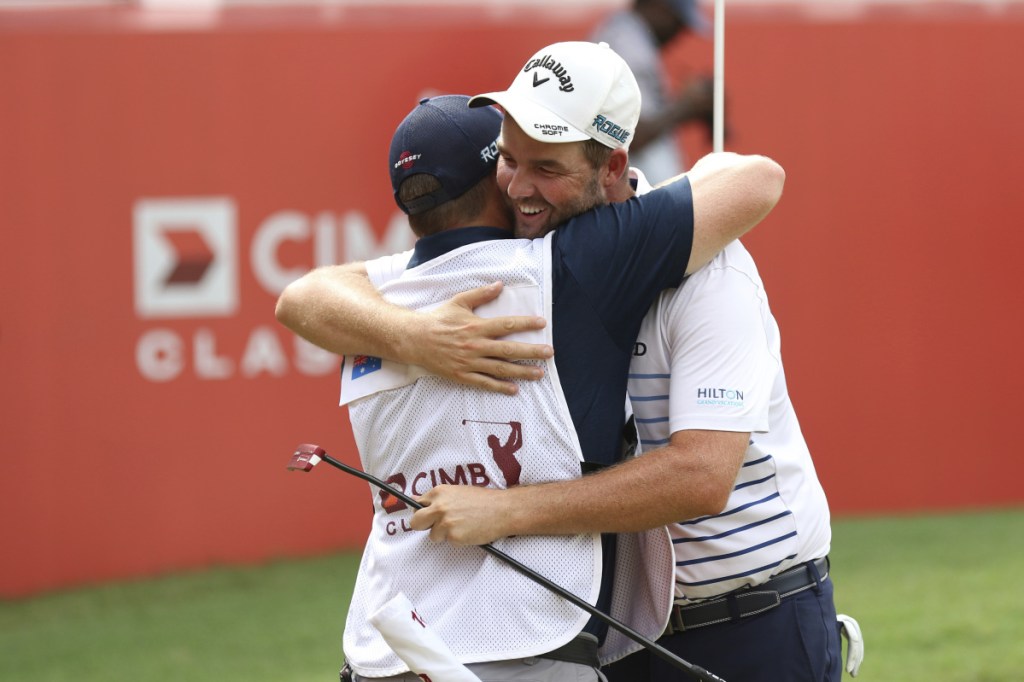 Marc Leishman of Australia celebrates with his caddie Sunday after winning the CIMB Classic golf tournament in Kuala Lumpur, Malaysia. It was Leishman's fourth victory on the PGA Tour.