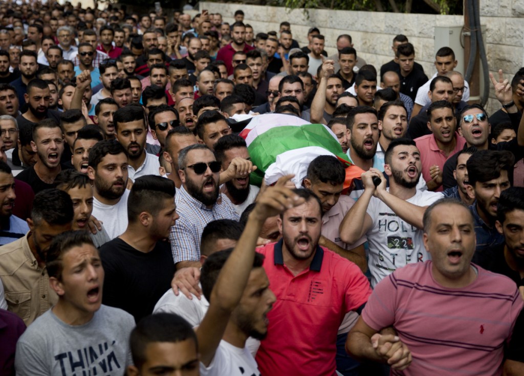 Palestinians carry the body of Aisha Rabi, 48, during her funeral in the West Bank village of Biddya on Saturday. Rabi was struck in the head by a stone thrown by Israeli settlers, Palestinians said.