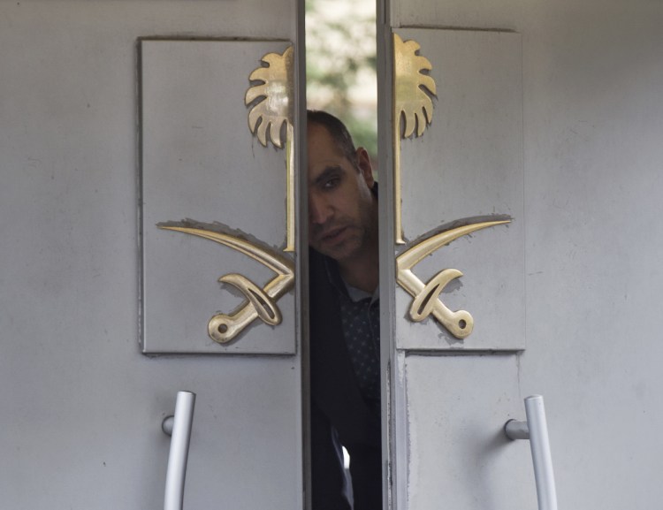A guard peers out the doors of Saudi Arabia's consulate in Istanbul, where Turkish officials say columnist Jamal Khashoggi was killed by order of the Saudi government. He was last seen entering the building Oct. 2.