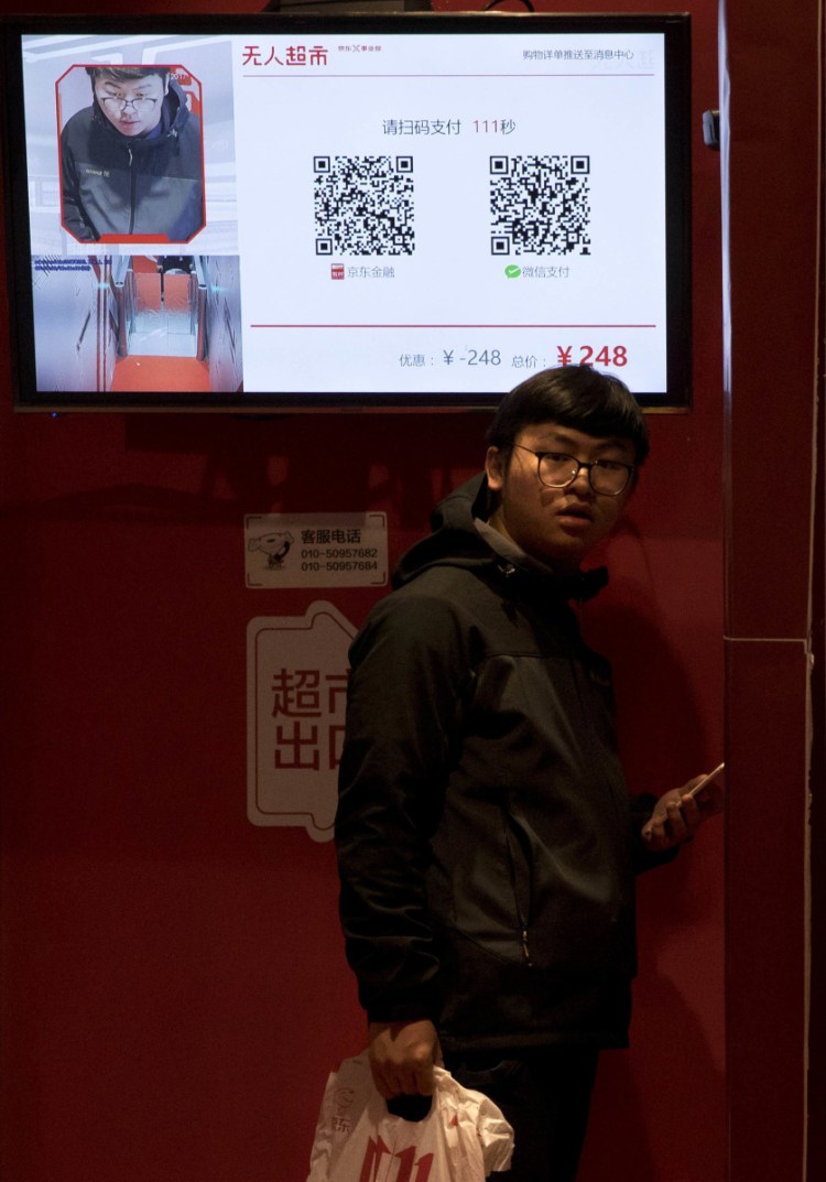 A shopper waits to leave an unstaffed convenience store in Beijing that uses facial recognition to take payments. 