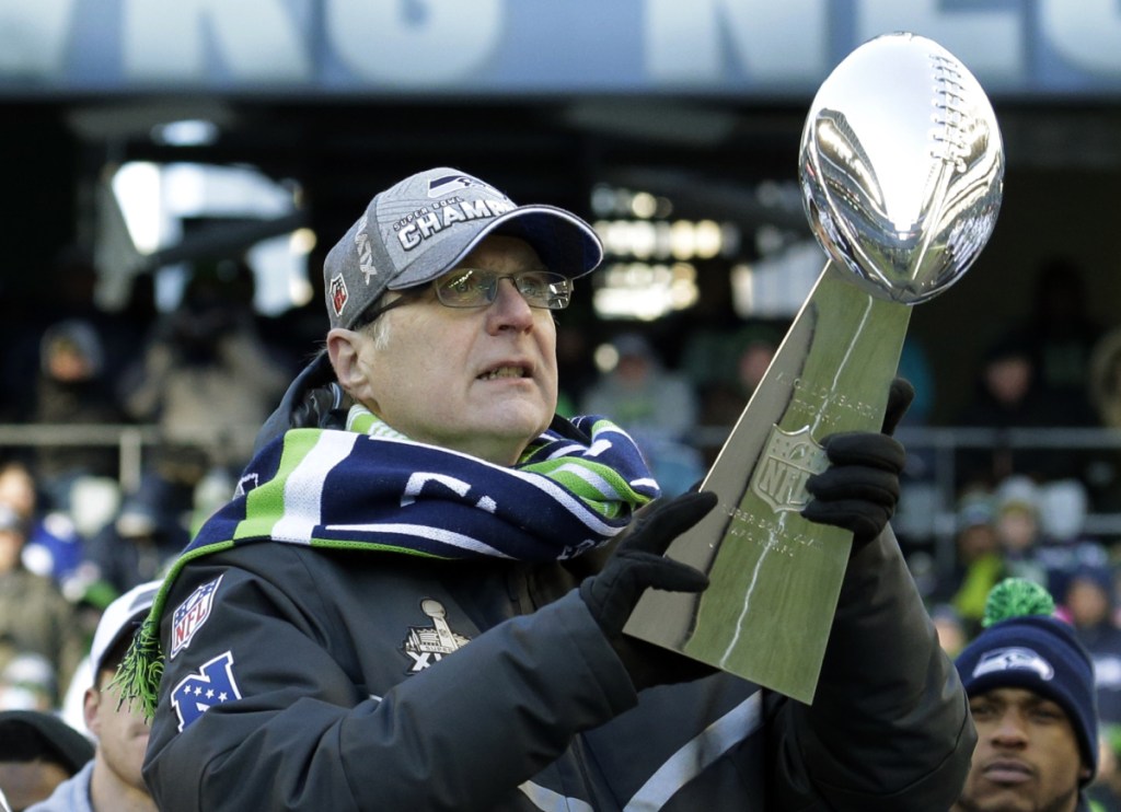 FILE--In this Feb. 5, 2014, file photo, Seattle Seahawks owner Paul Allen lifts the Vince Lombardi trophy during a celebration at CenturyLink Field in Seattle. Allen, billionaire owner of the Portland Trail Blazers and the Seattle Seahawks and Microsoft co-founder, died Monday, Oct. 15, 2018 at age 65. Earlier this month Allen said the cancer he was treated for in 2009, non-Hodgkin's lymphoma, had returned. (AP Photo/Ted S. Warren, file)