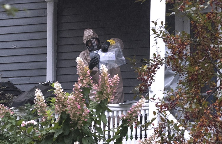A person in a hazmat suit appears to be handling a letter that is enclosed in a plastic bag in Bangor on Monday. A hazardous materials team was called to investigate a suspicious letter sent to the home of Republican Sen. Susan Collins, officials said.