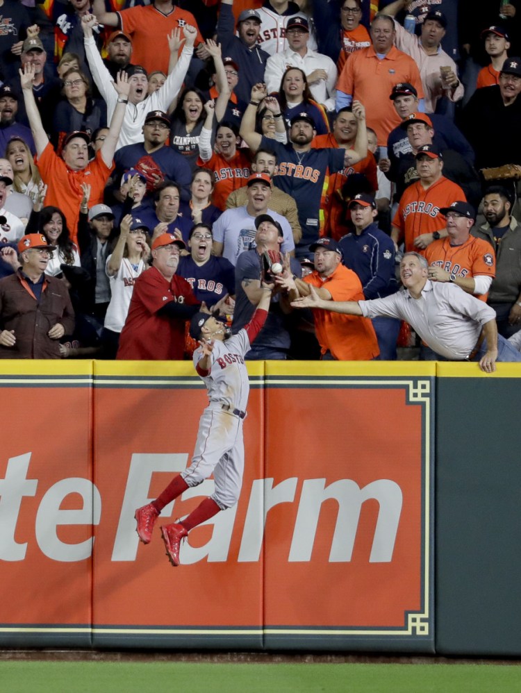 Fans interfere with Boston Red Sox right fielder Mookie Betts trying to catch a ball hit by Houston Astros' Jose Altuve during the first inning in Game 4 of the ALCS on Wednesday night in Houston. Altuve was called out. (AP Photo/Frank Franklin II)
