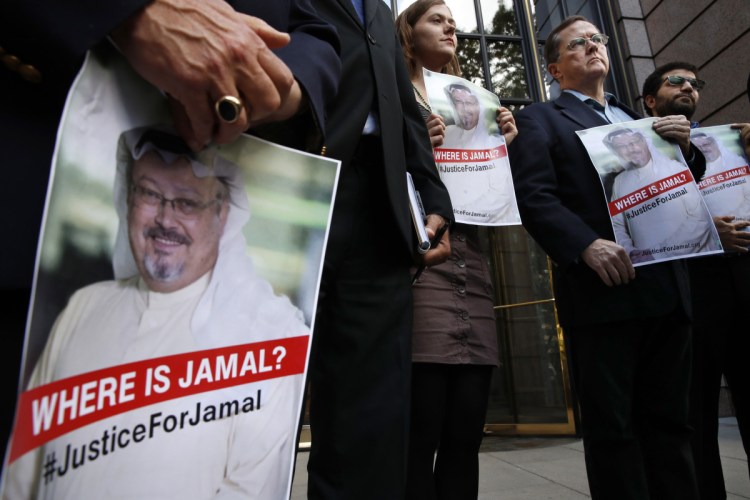 Alyssa Edling, center, and Thomas Malia, second from right, both with PEN America, join others as they hold signs of missing journalist Jamal Khashoggi, during a news conference about his disappearance in Saudi Arabia, on Oct. 10 in front of The Washington Post in Washington.