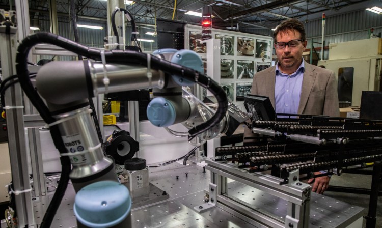 Brian Pelke, president of Kay Manufacturing, an automotive parts company in Calumet City, Ill., shows off the company's newest collaborative robots, or cobots. Pelke said he expects his new cobots to give him an additional competitive edge, and that he has never laid anyone off as a result of automation.