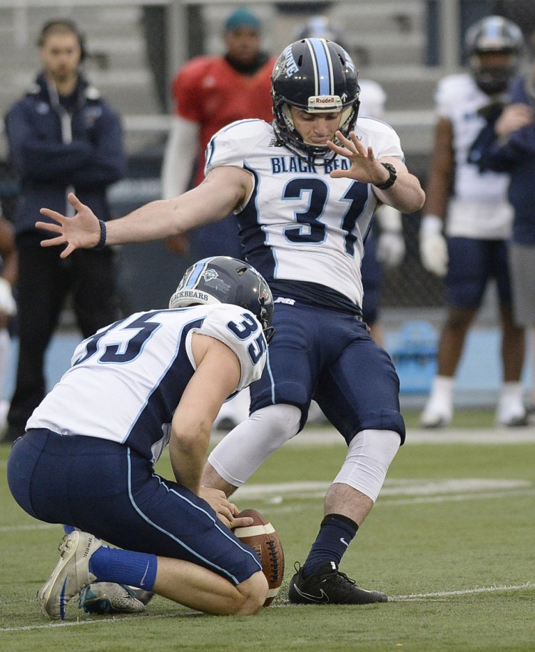 With teammate Derek Deoul holding, University of Maine kicker Kenny Doak attempts a field goal in a game last spring in Orono. Last season's demotion "definitely lit a fire under my butt," says Doak, who struggled in his freshman year. "I'm a competitive kid and I don't like to sit on the sidelines and watch other people do what I can do. I took it as an initiative to work really hard last offseason."