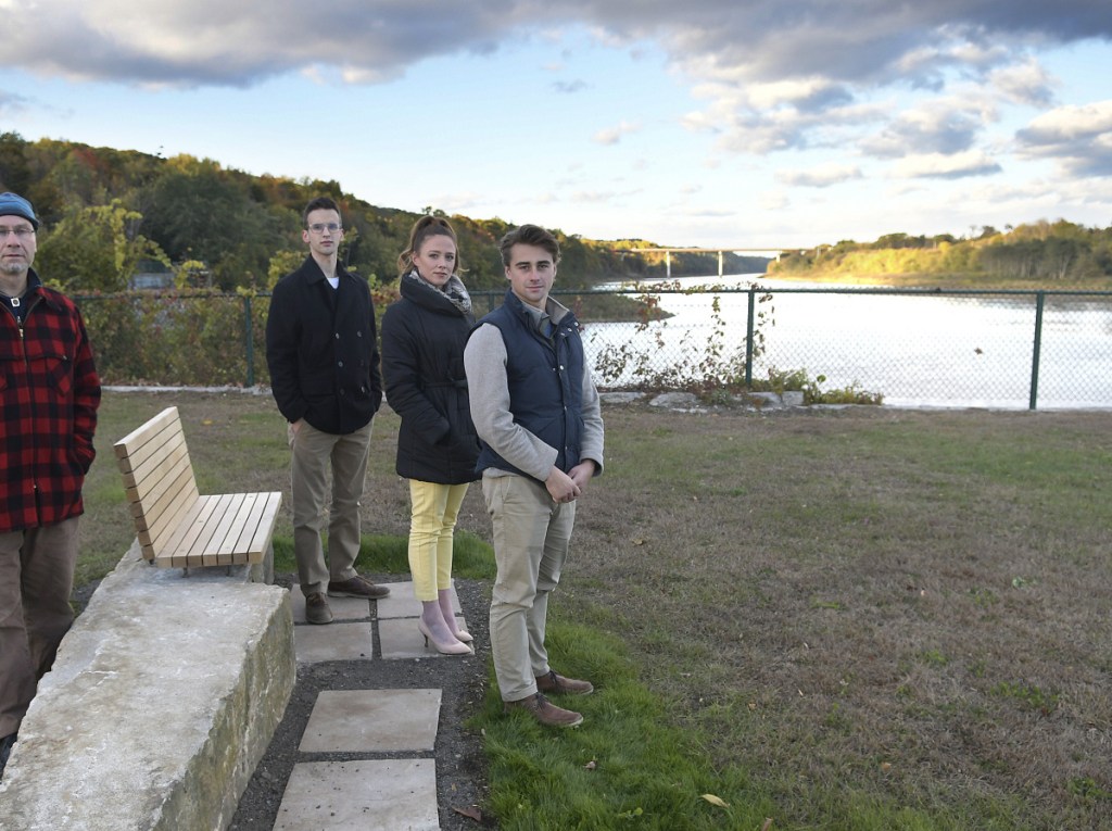 University of Maine at Augusta architecture lab supervisor Oliver Solmitz, left, and students Andrew Treworgy, from left, Shauna Riordan and Sam Gerken stand Thursday with a bench they created at Mill Park in Augusta.