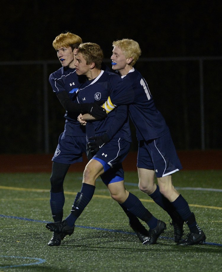 Yarmouth's Aidan Hickey, center, is swarmed by teammates Eric LaBrie, left, and Jack Jones after Hickey scored the game's first goal Tuesday.
