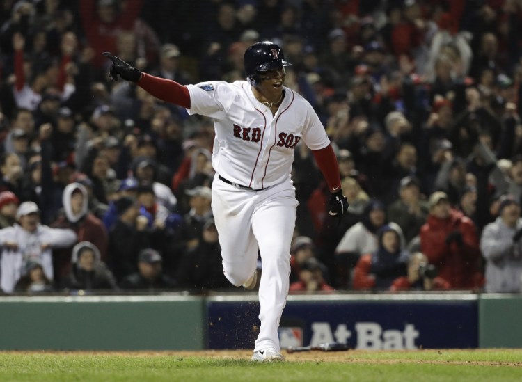 Rafael Devers of the Red Sox hits an RBI single to score Andrew Benintendi in the fifth inning of Game 1 of the World Series Tuesday night in Boston.