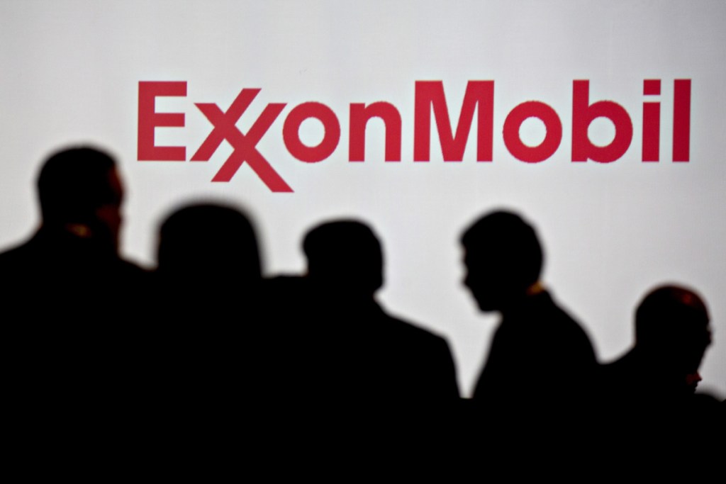 Attendees stand near Exxon Mobil Corp. signage during a conference in Washington, D.C., on Tuesday, June 26, 2018. Bloomberg/Andrew Harrer