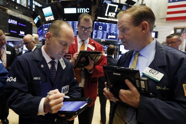 Michael Urkonis, from left, William Lawrence and Michael Smyth work at the New York Stock Exchange on Monday. "Investors are on pins and needles," said a Wells Fargo Private Bank official.