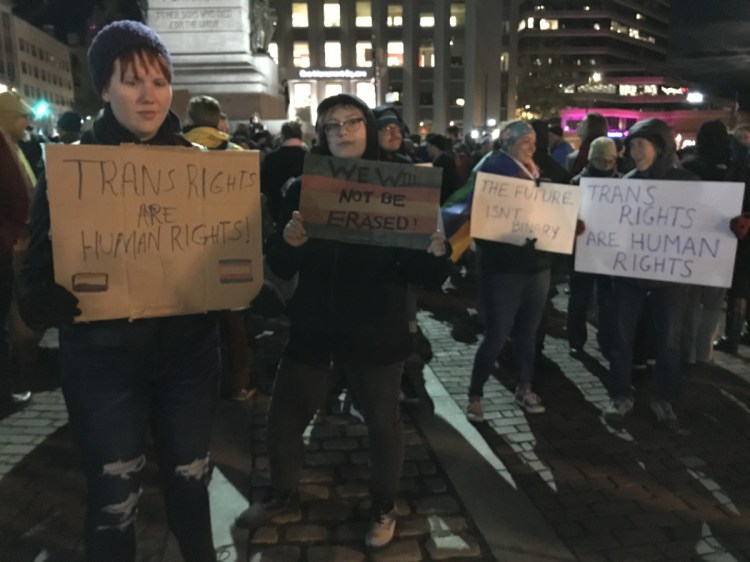 Kat Pyburn of Westbrook, left, and Elliott Babcock of Portland, center, join more than 300 other people supporting transgender rights during a protest in Monument Square on Wednesday night.