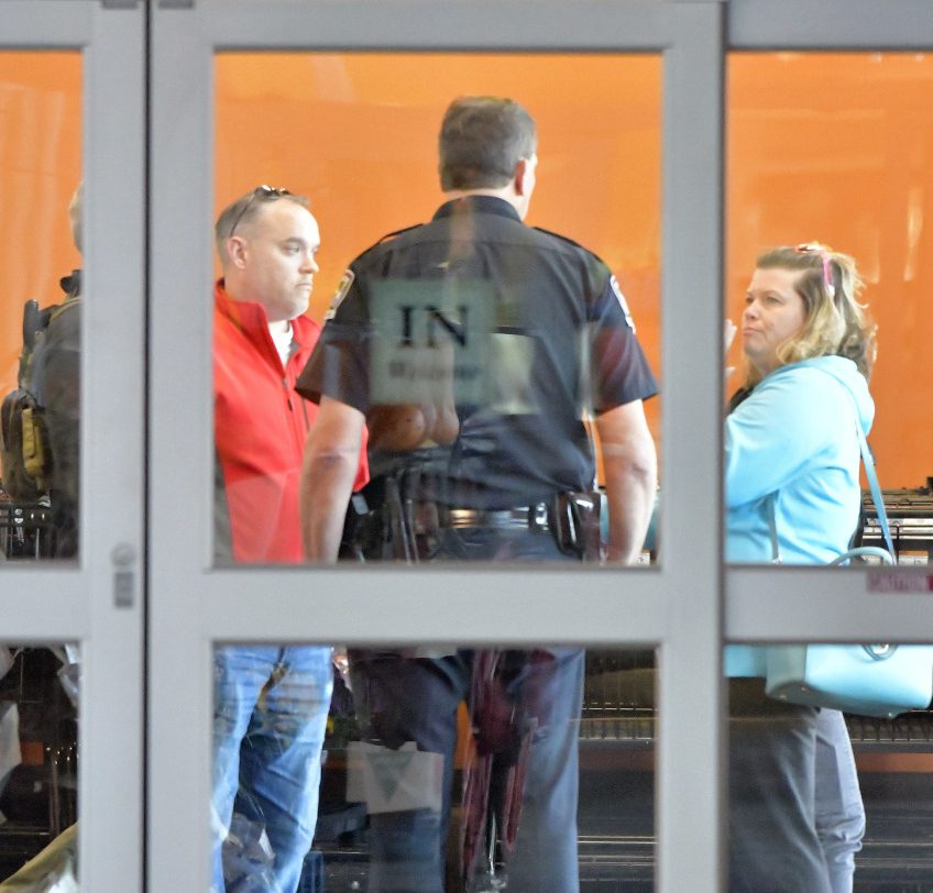 A police officer with the Louisville Metro Police Department interviews customers following a shooting that left two people dead and a suspect in custody at a Kroger grocery, Wednesday, Oct. 24, 2018, in Jeffersontown, Ky. A man fatally shot another man inside a Kroger grocery store, shot and killed a woman in the parking lot, and then exchanged fire with an armed bystander who intervened before he fled the scene on the outskirts of Louisville, Kentucky, on Wednesday, police said. He was captured shortly afterward. (AP Photo/Timothy D. Easley)