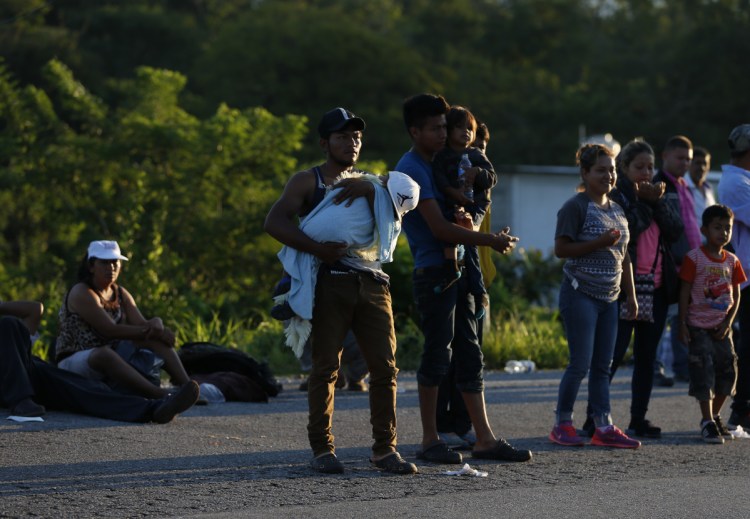 Central American migrants try to hitch rides on passing trucks near Mapastepec, Mexico, on Thursday as thousands head north hoping to reach the U.S. border, still over 1,000 miles away.