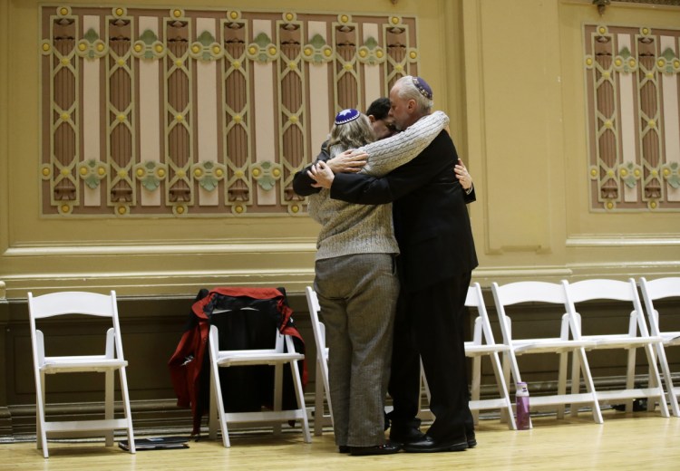 Rabbi Jeffrey Myers, right, of Tree of Life/Or L'Simcha Congregation hugs Rabbi Cheryl Klein, left, of Dor Hadash Congregation and Rabbi Jonathan Perlman during a community gathering Sunday that was held in the aftermath of a deadly shooting at the Tree of Life synagogue in Pittsburgh.