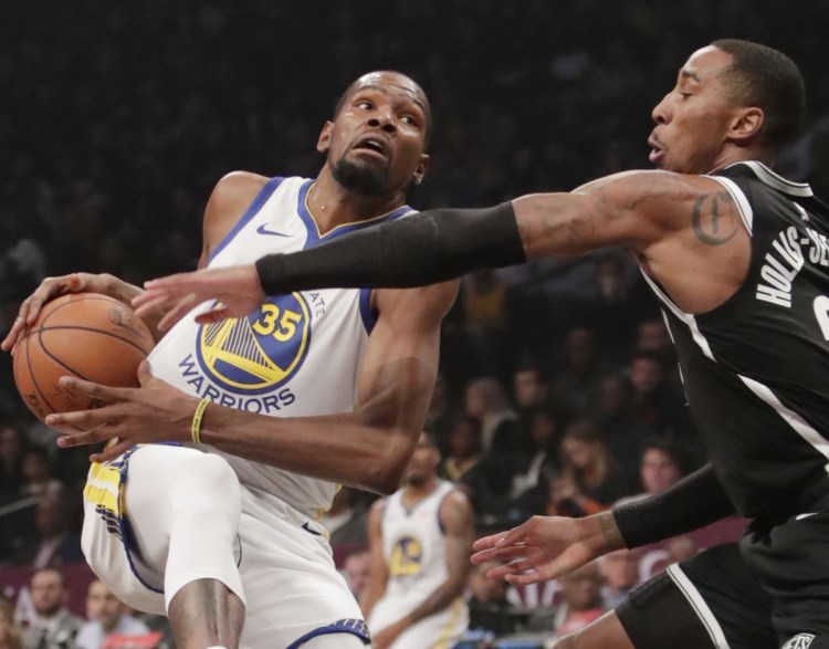 Kevin Durant of the Golden State Warriors heads to the basket Sunday against Caris LeVert of the Brooklyn Nets in the first half. Durant scored 34 in a 120-114 victory.