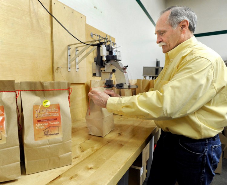 In this file photo from 2010, Scott Rehart, owner of Montecito Roadhouse Inc. in Portland, stitches a bag of tortilla chips.