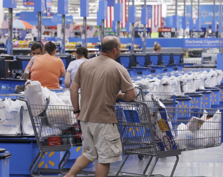 A shoppers head for a checkout at the Walmart Supercenter store in Springdale, Ark. In an effort to speed up checking out, Walmart is enabling clerks to process purchases in busy store aisles.