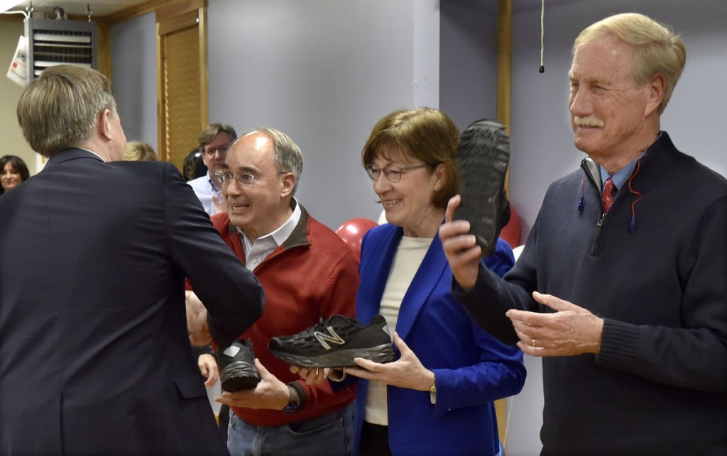 U.S. Sen. Angus King, I-Maine, right, holds up a New Balance athletic shoe as Dave Wheeler, left, of the company hands U.S. Sen. Susan Collins, R-Maine, and U.S. Rep. Bruce Poliquin, R-2nd District, a sample shoe on Tuesday in Norridgewock.