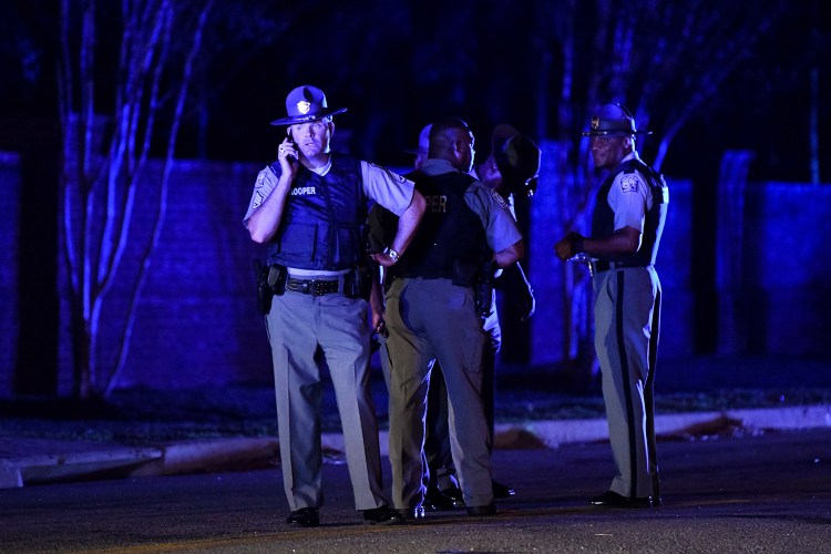 South Carolina state troopers gather Wednesday evening near the neighborhood where seven law enforcement officers were shot, one fatally, in Florence, S.C.