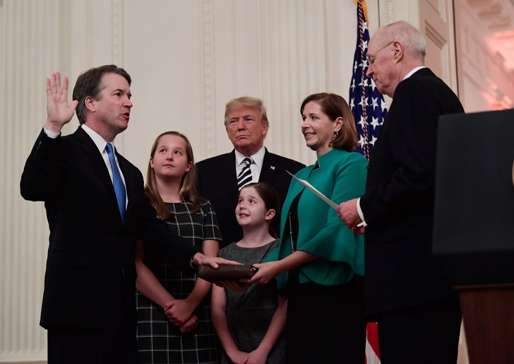 Retired Justice Anthony Kennedy, right, ceremonially swears in Supreme Court Justice Brett Kavanaugh, with President Trump at rear, in the East Room of the White House in Washington on Monday. Ashley Kavanaugh holds the Bible and daughters Margaret, left, and Liza, watch. 