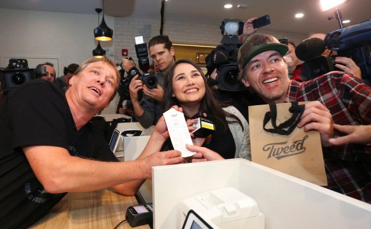 Canopy Growth CEO Bruce Linton, left to right, poses with the receipt for the first legal cannabis for recreation use sold in Canada to Nikki Rose and Ian Power at the Tweed shop on Water Street in St. John's N.L. at 12:01 am NDT on Wednesday.