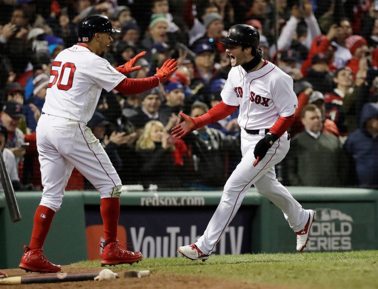 Andrew Benintendi celebrates with Mookie Betts after scoring with Betts on a two-run single by J.D. Martinez in the fifth inning of Game 2 of the World Series on Wednesday night in Boston. The hit proved to be the game winner.
