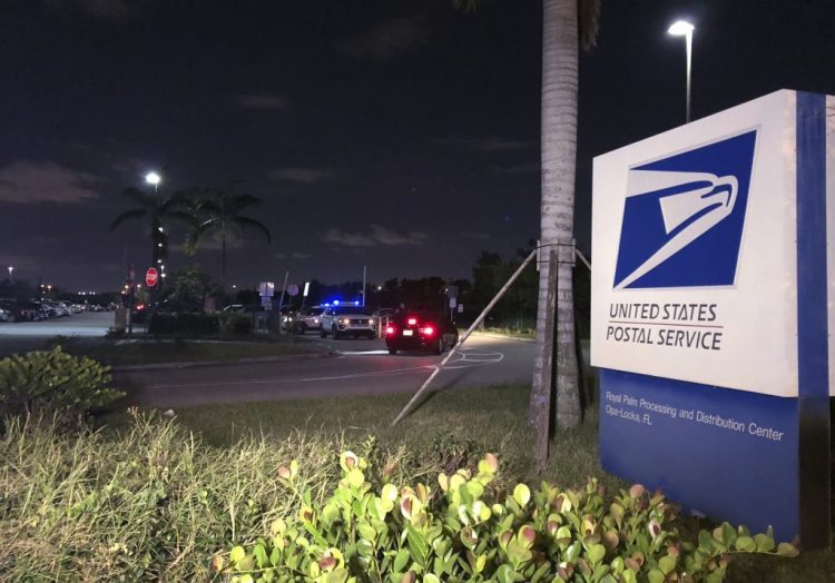 Postal service police screen employees entering the Royal Palm processing and Distribution Center on Thursday night in Opa-locka, Fla. A law enforcement source tells The Associated Press that Miami-Dade police went to the facility at the request of the FBI in connection with the mail bomb investigation.