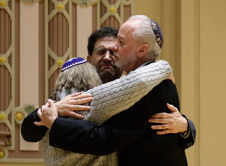 Rabbi Jeffrey Myers, right, of Tree of Life/Or L'Simcha Congregation hugs Rabbi Cheryl Klein, left, of Dor Hadash Congregation and Rabbi Jonathan Perlman during a community gathering held in the aftermath of the deadly shooting in October.