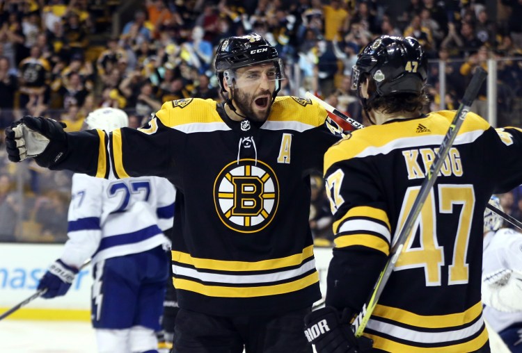 Patrice Bergeron, left, expects to play for the Bruins in their opener Wednesday night, but Torey Krug will not play after suffering a broke left ankle. 