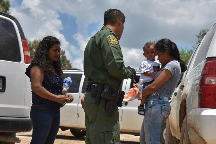 Two young mothers from Honduras and their children are detained by Border Patrol after rafting across the Rio Grande in Granjeno, Texas, in June. 