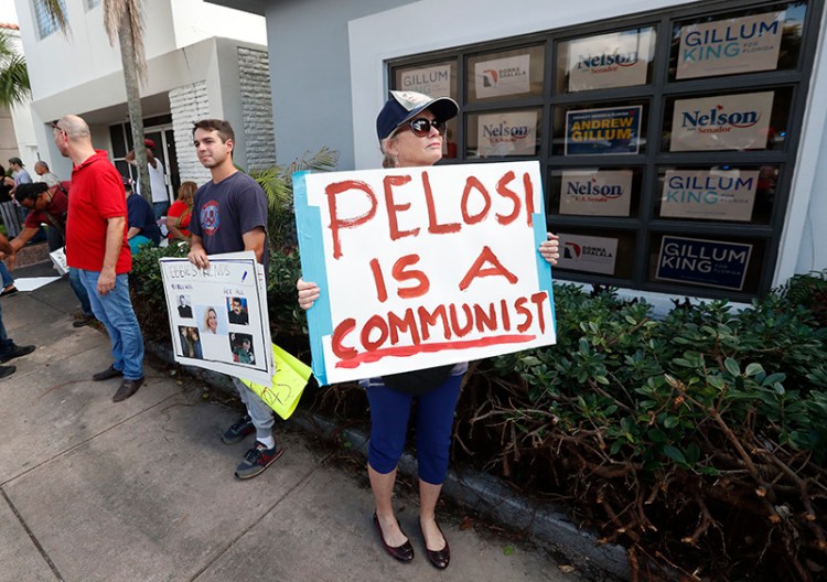 Demonstrators stand outside a building where House Minority Leader Nancy Pelosi spoke to volunteers at a get out the vote event for Florida Democratic congressional candidates Donna Shalala and Debbie Mucarsel-Powell on Wednesday in Coral Gables, Fla.