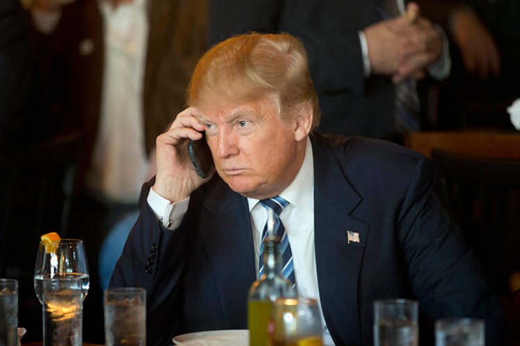 Presidential candidate Donald Trump listens to his mobile phone in 2016.