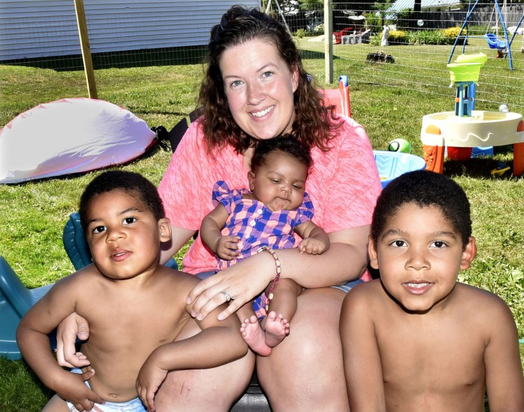 Mindy Saint Martin sits with her children — from left, Marcus, Mya and Donovan  — on July 9 at their home in Waterville. Her husband, Lexius, has been deported to Haiti.