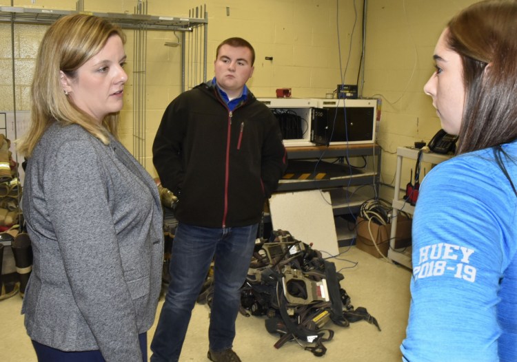 Beth Carlton, left, student services coordinator at Mid-Maine Technical Center in Waterville speaks with students Bryce Scott and Michaela Huey about the Say Something app for cellphones. 